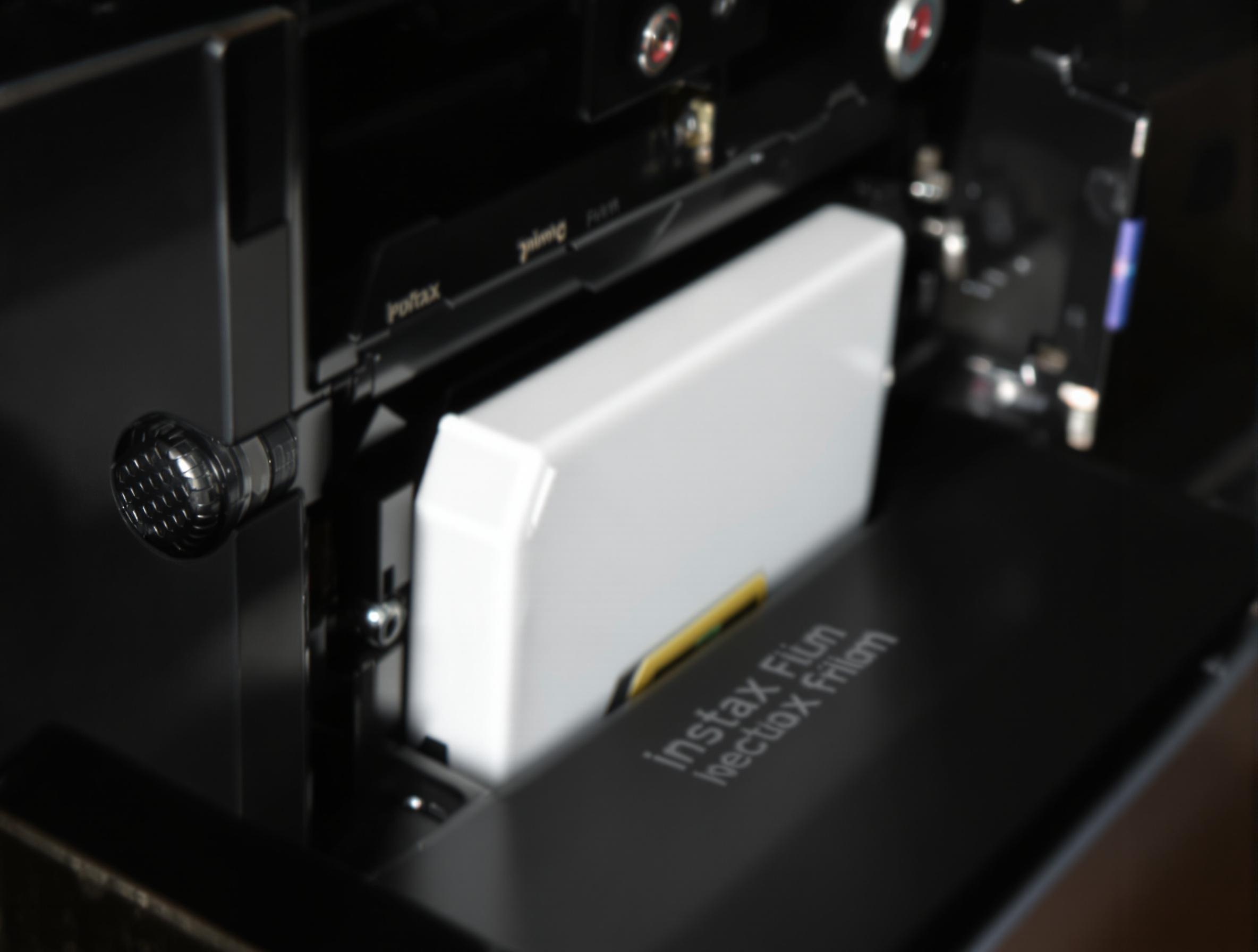 Cartouche Instax mal insérée, vue macro du blocage dans l'appareil