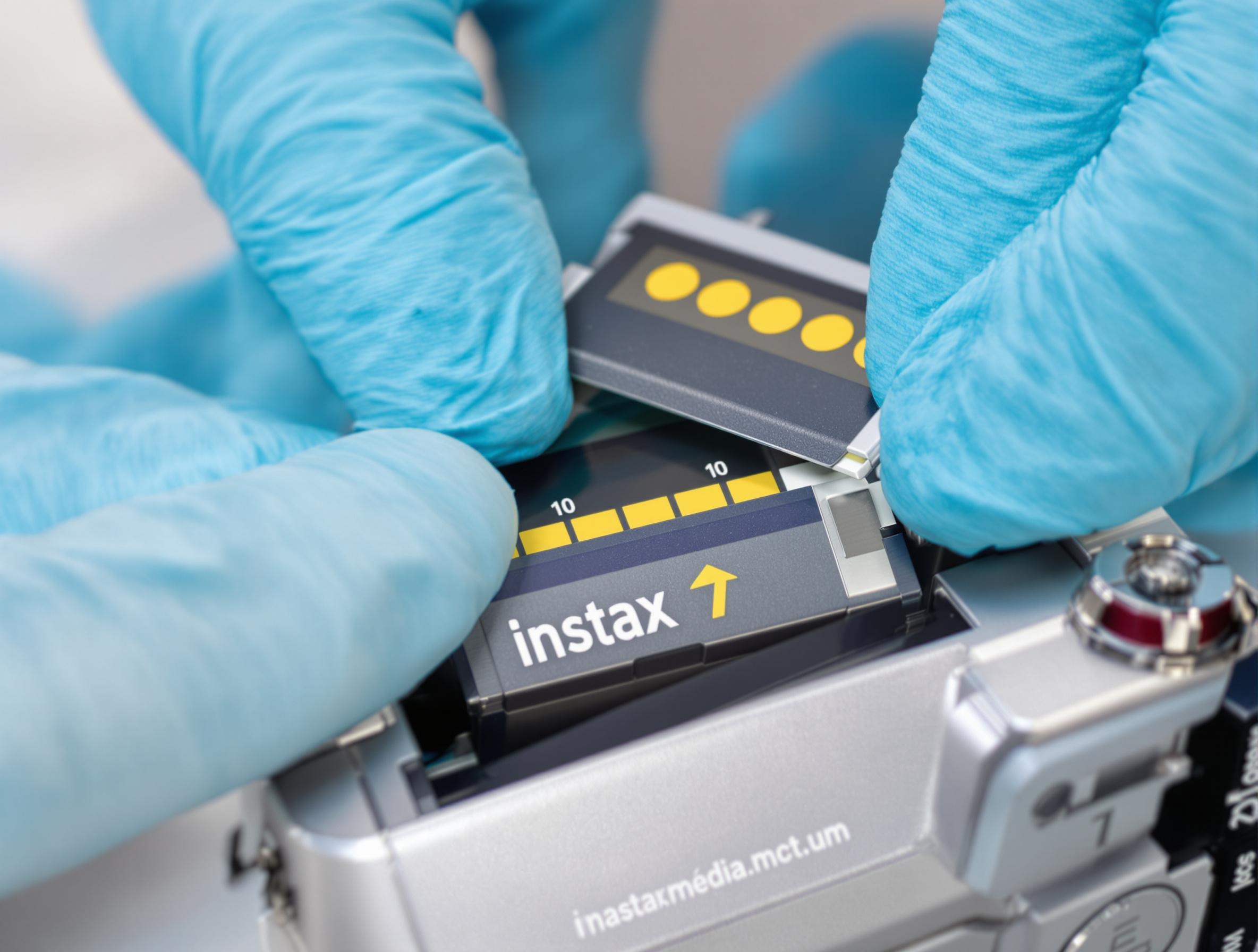 Insertion correcte d'une cartouche Instax avec repères alignés